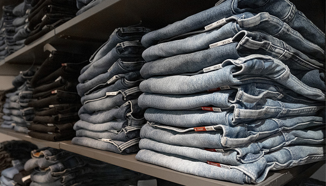 Stapels jeans op een plank