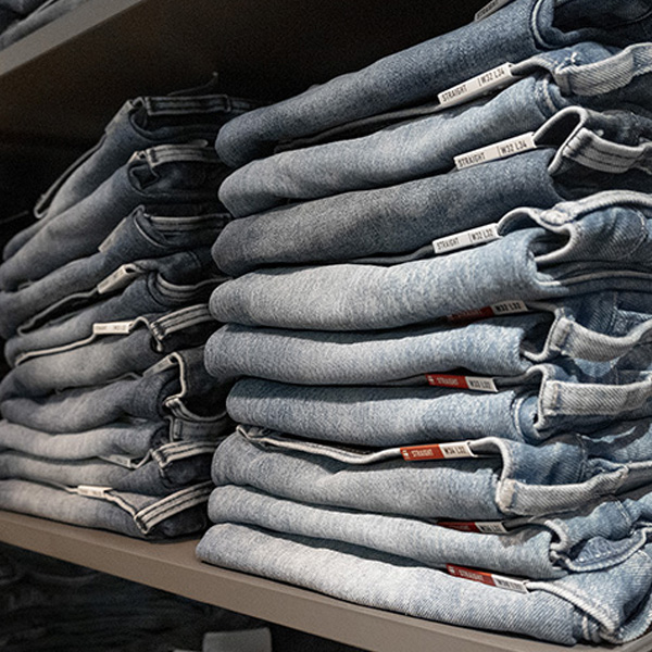Stapels jeans op een plank